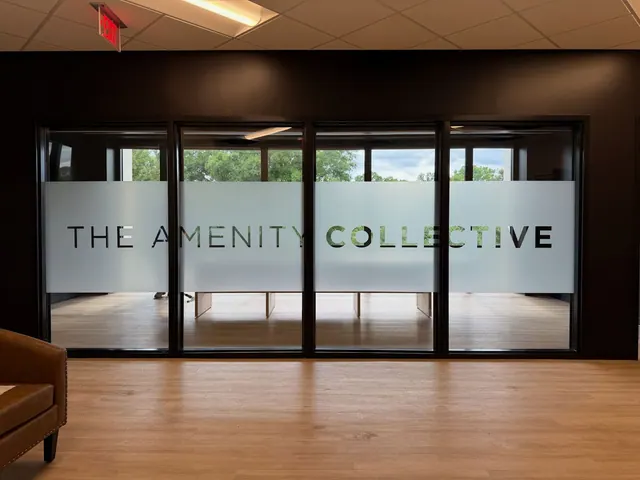 The Amenity Collective name in a frosted band across interior glass.